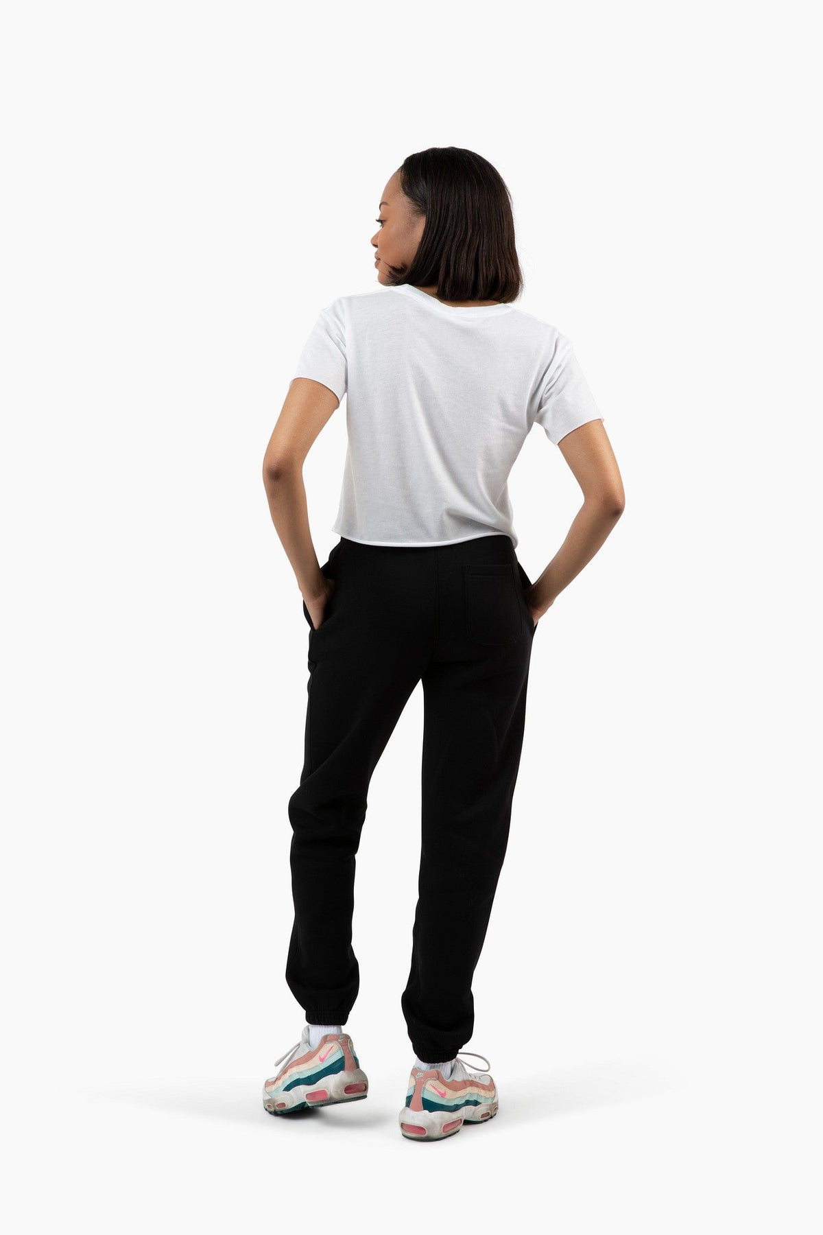 Person wearing a white t-shirt and black pants on a white background