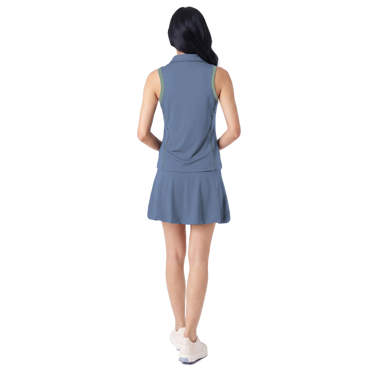 A woman is shown from the back wearing a sleeveless slate blue athletic top and matching skort, paired with white sneakers, against a solid white background.