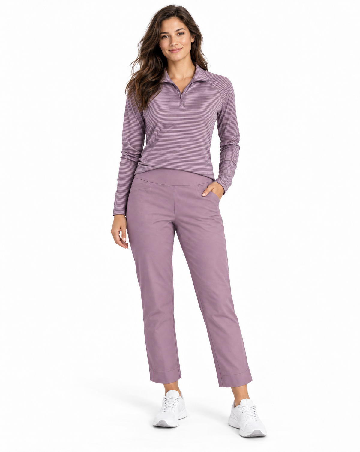 A woman modeling a matching two-piece athletic set consisting of a heathered dusty purple long-sleeve quarter-zip polo shirt and matching straight-leg cropped pants, paired with white sneakers on a white studio background.