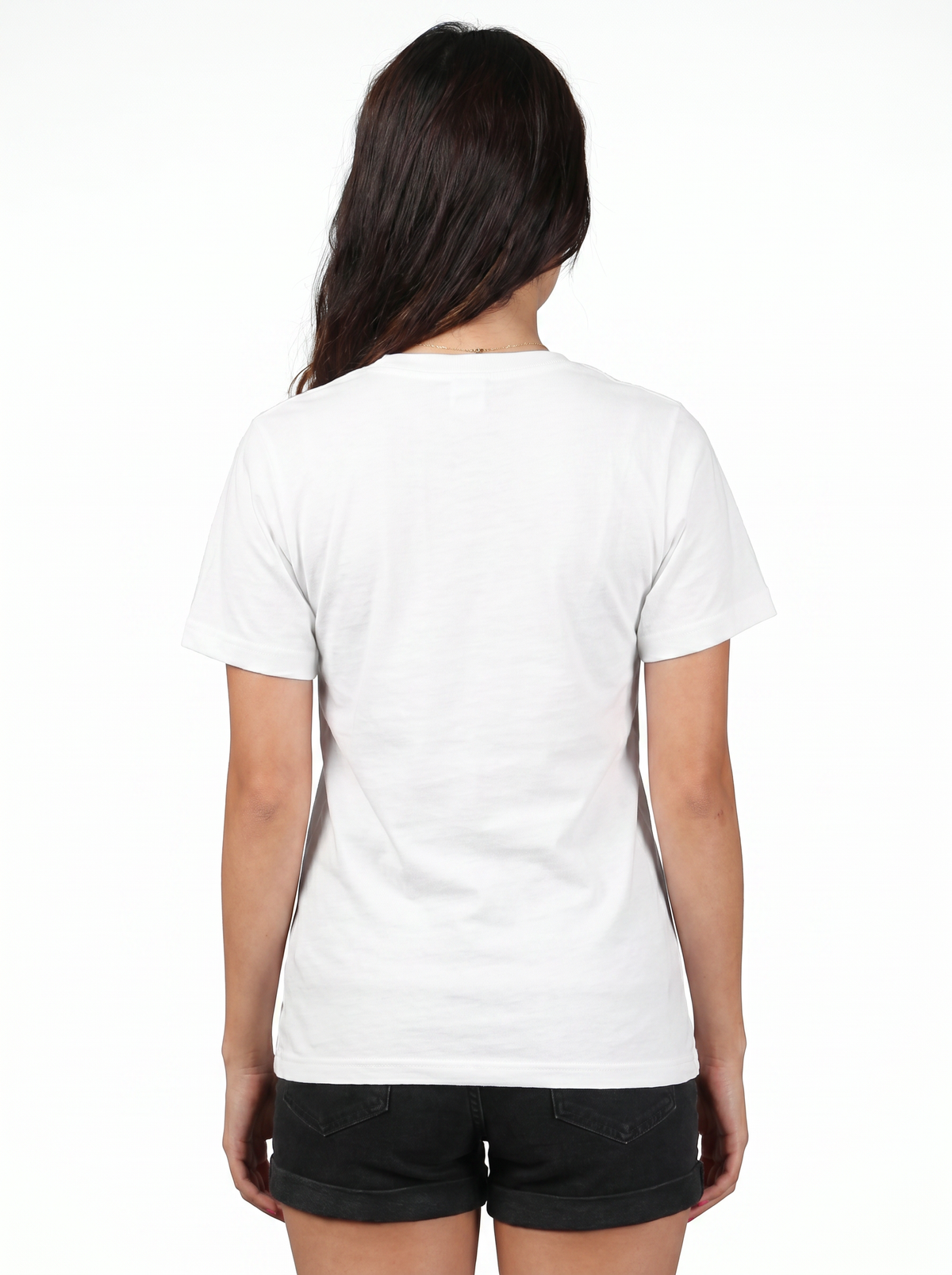 A woman viewed from behind wearing a plain white short-sleeve crewneck t-shirt and black shorts against a white studio background.