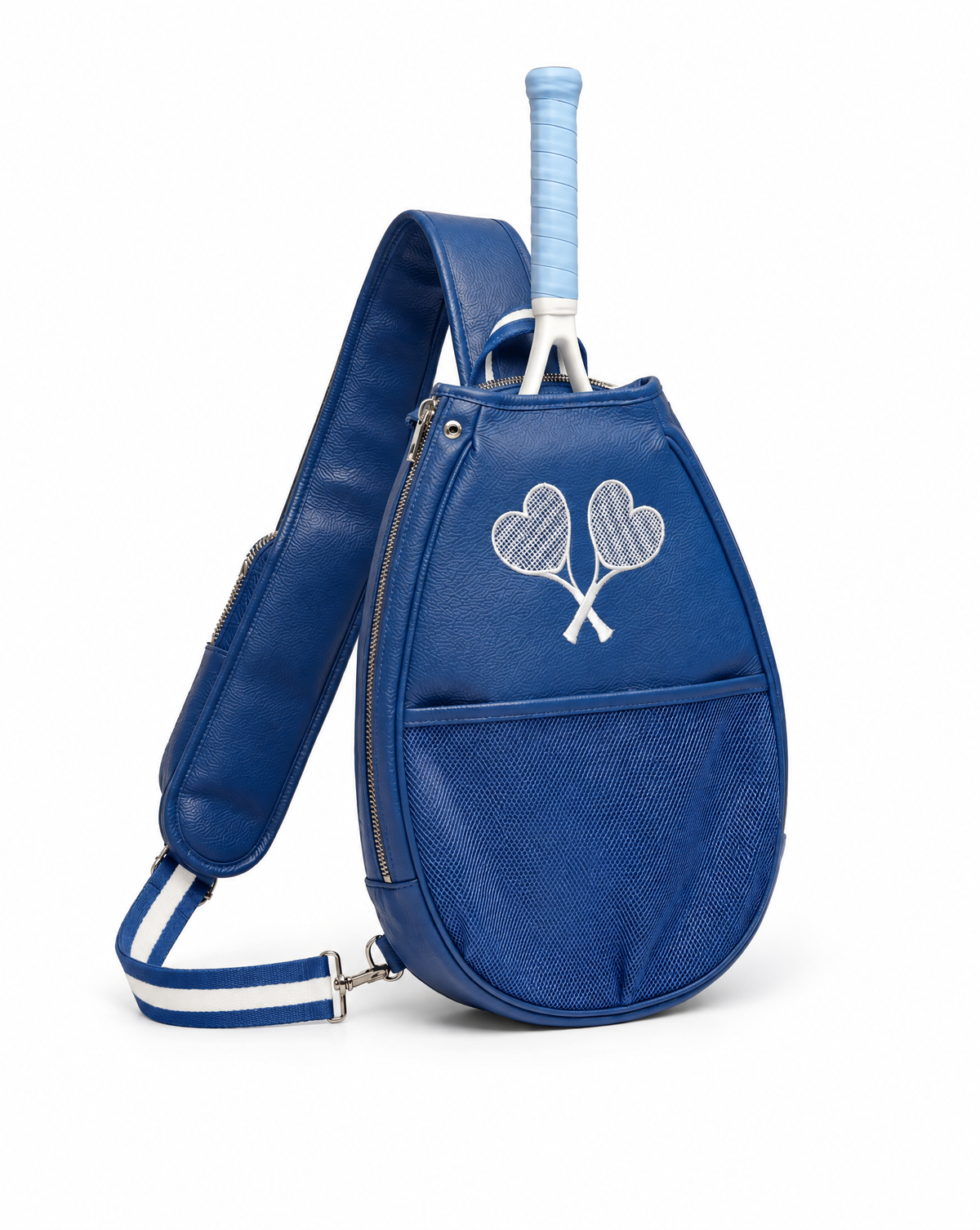 A royal blue tennis bag with a textured front pocket, a white embroidered crossed tennis rackets motif, and a light blue tennis grip tucked into the top opening. The bag features a wide shoulder strap with white stripes and is photographed on a clean whit