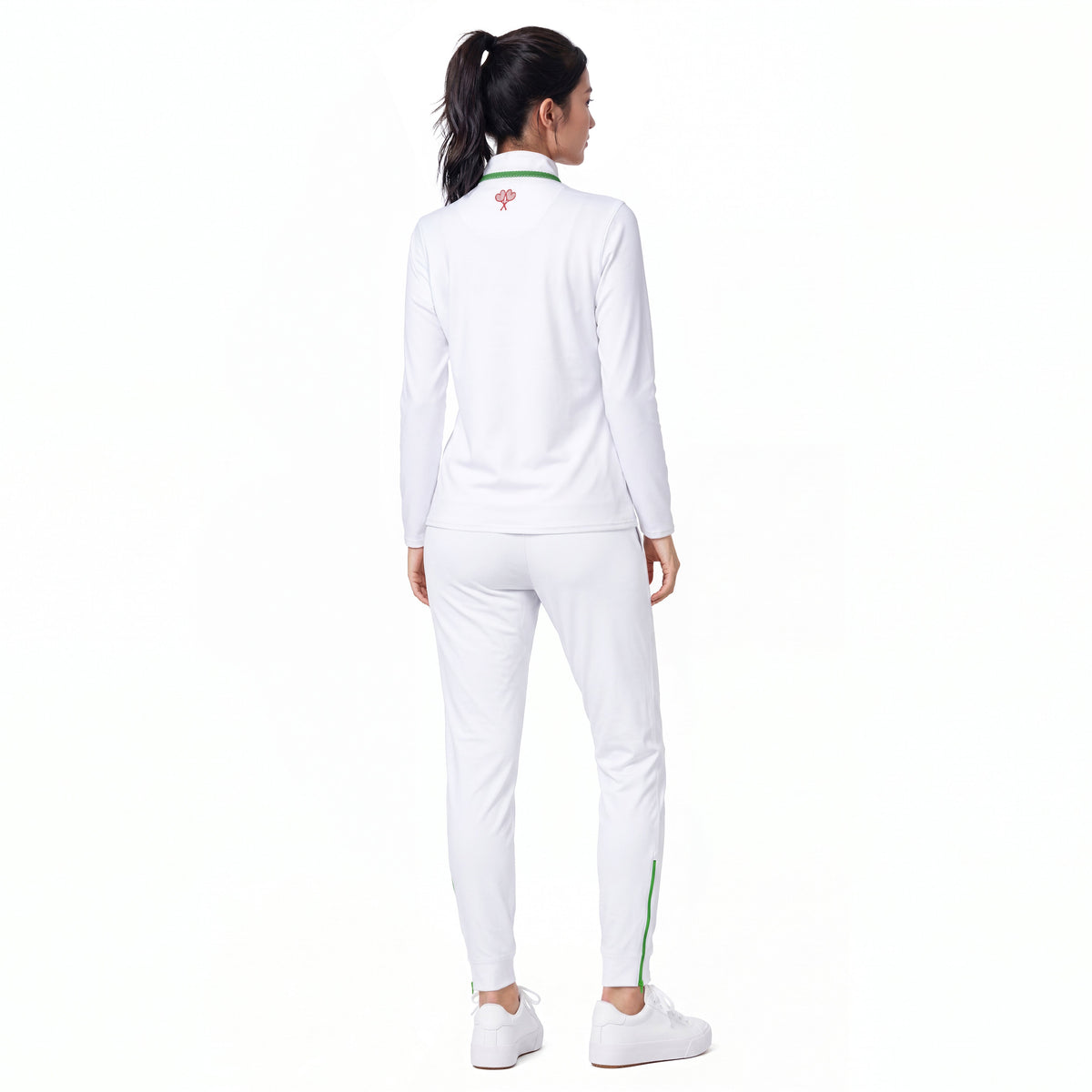 A woman shown from the back wearing a white athletic tracksuit with a green and pink logo on the collar, white pants with a green stripe, and white sneakers, set against a plain white background.