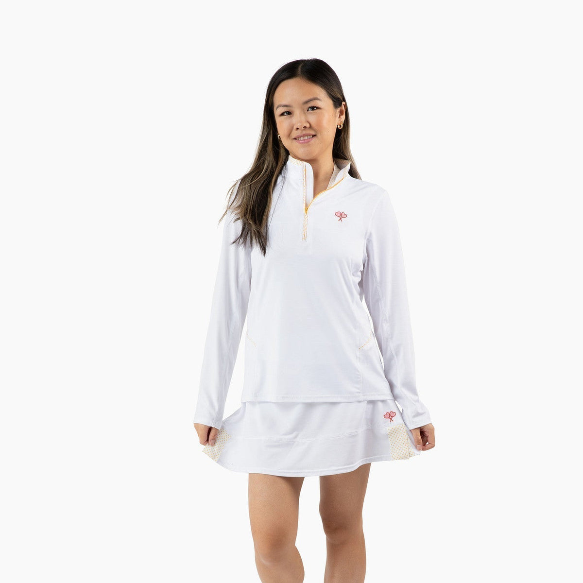 Woman wearing a white tennis outfit with a logo on a white background