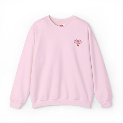 Pink sweatshirt with a small design on the chest against a white background