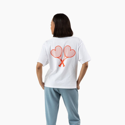 Person wearing a white t-shirt with a heart design on the back, standing against a white background.