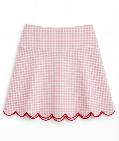 Pink gingham skirt with scalloped edge on a white background