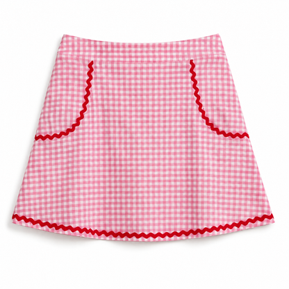 A pink and white gingham mini skirt with red wavy trim along the pockets and hem, displayed flat against a white background.
