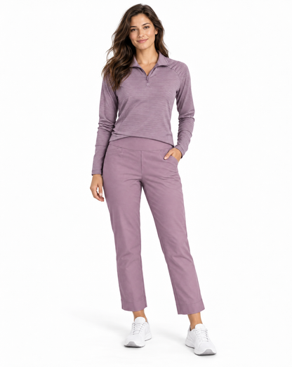 A woman modeling a matching two-piece athletic set consisting of a heathered dusty purple long-sleeve quarter-zip polo shirt and matching straight-leg cropped pants, paired with white sneakers on a white studio background.