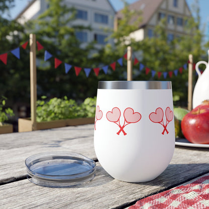White tumbler with red heart designs on a picnic table 