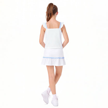 A girl shown from the back wearing a white sleeveless ruffled top and matching white mini skirt with light blue trim, paired with white sneakers, on a plain white studio background.