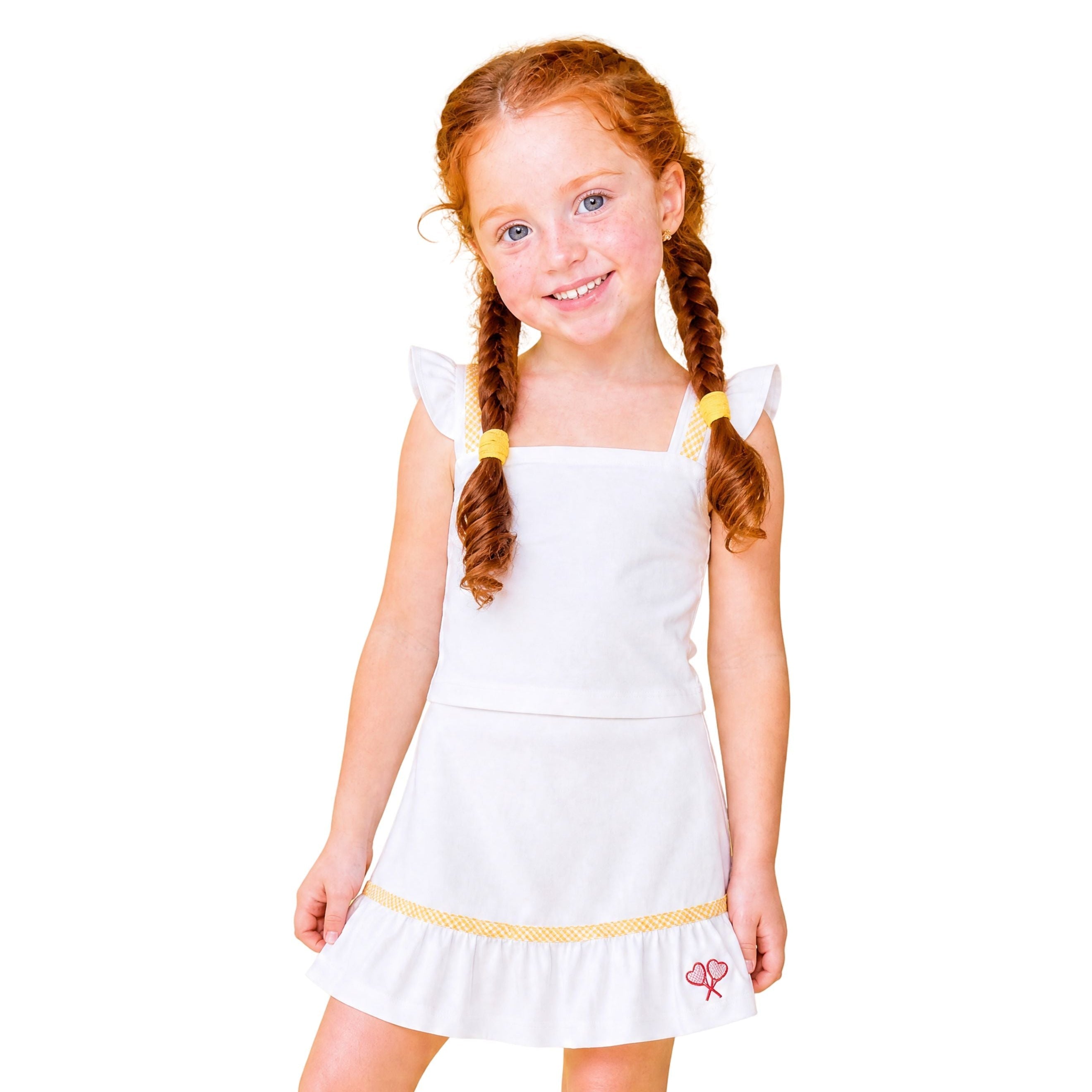 Young girl wearing a white dress with yellow trim on a white background