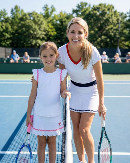 Woman and young girl on a tennis court holding tennis rackets