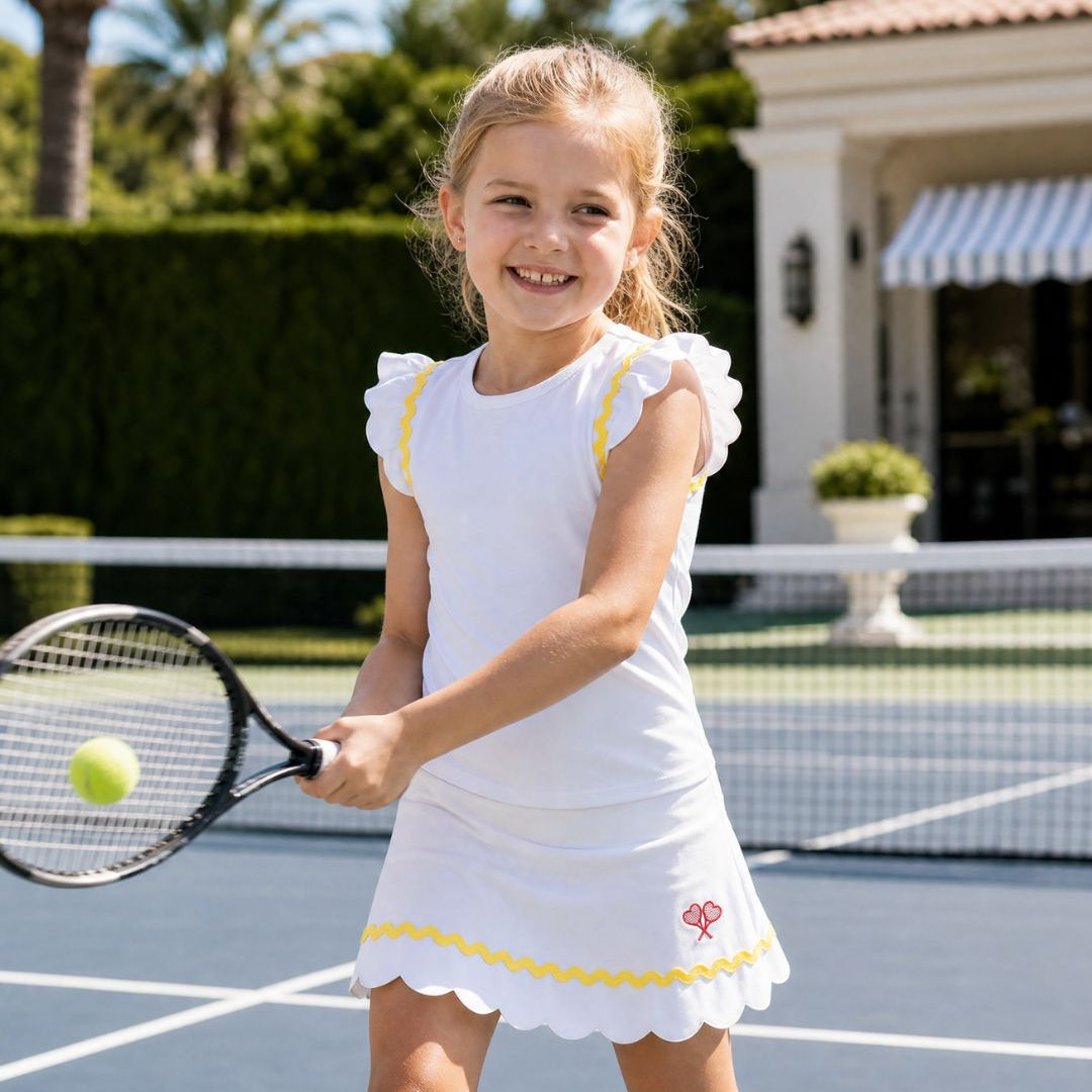 Young girl playing tennis on a court with a house and palm trees in the background