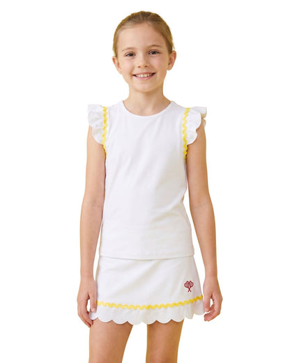 Young girl wearing a white outfit with yellow trim on a white background