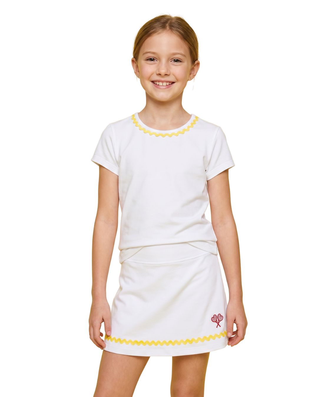 Young girl wearing a white dress with yellow trim on a white background