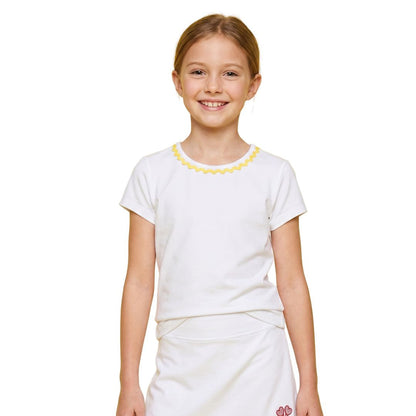 Young girl wearing a white top and skirt with yellow trim on a white background