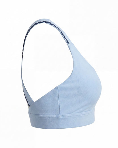 Light blue sports bra with thin straps on a white background