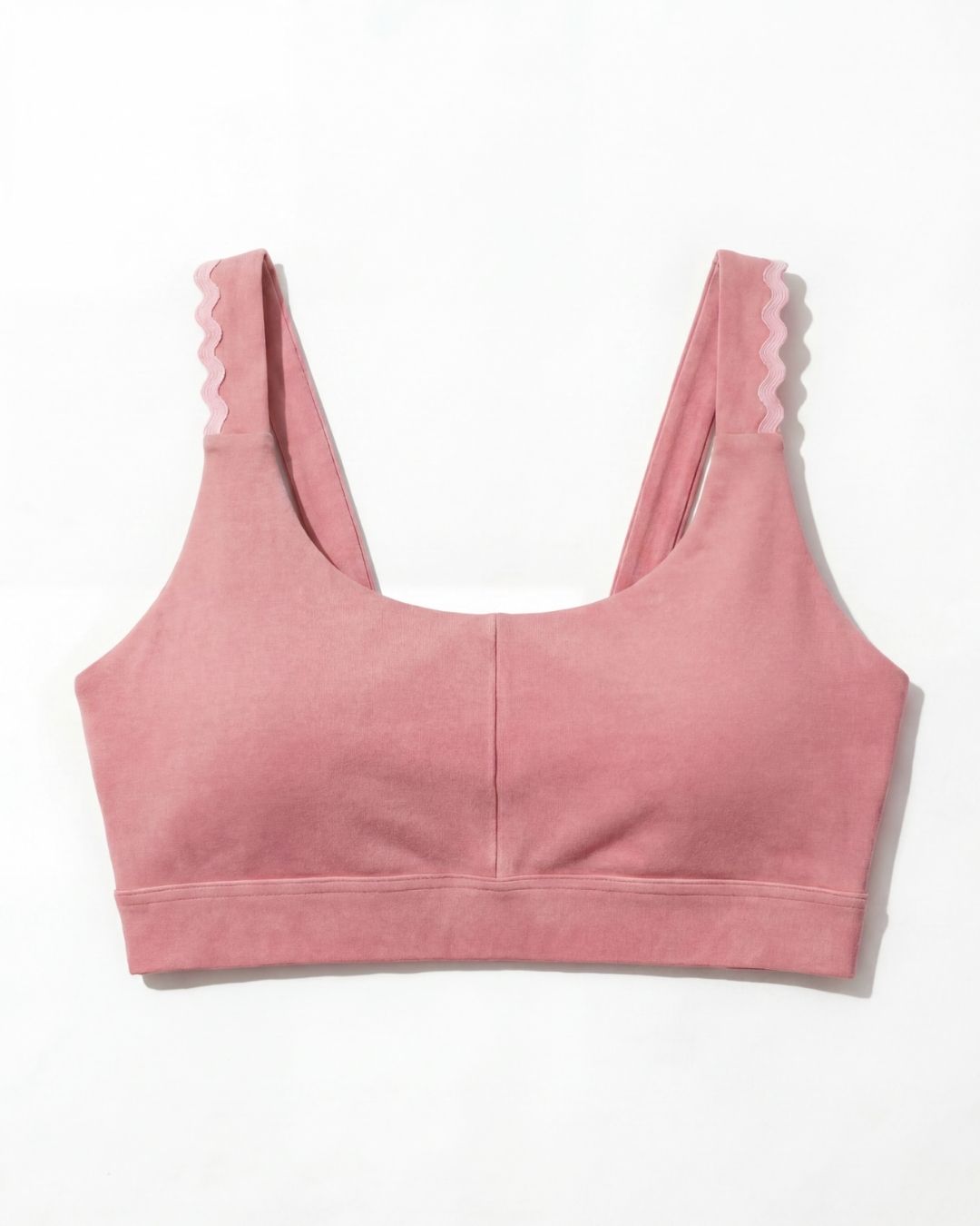 Pink sports bra with pink trim on a white background