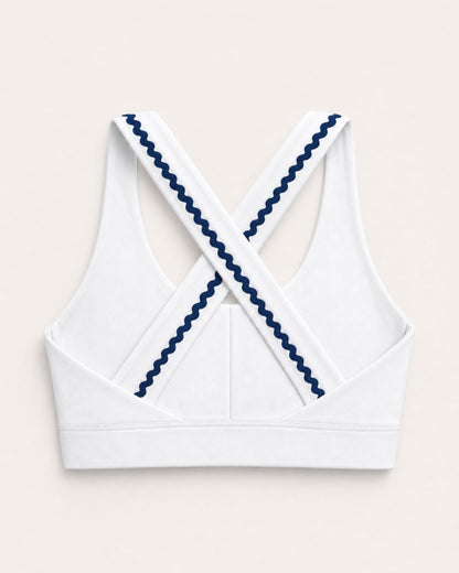 White sports bra with blue trim on a light beige background