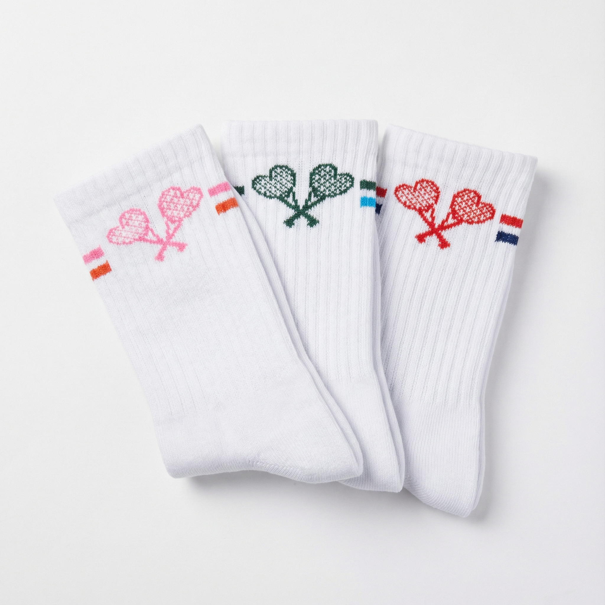 Three white socks with embroidered designs on a light gray background