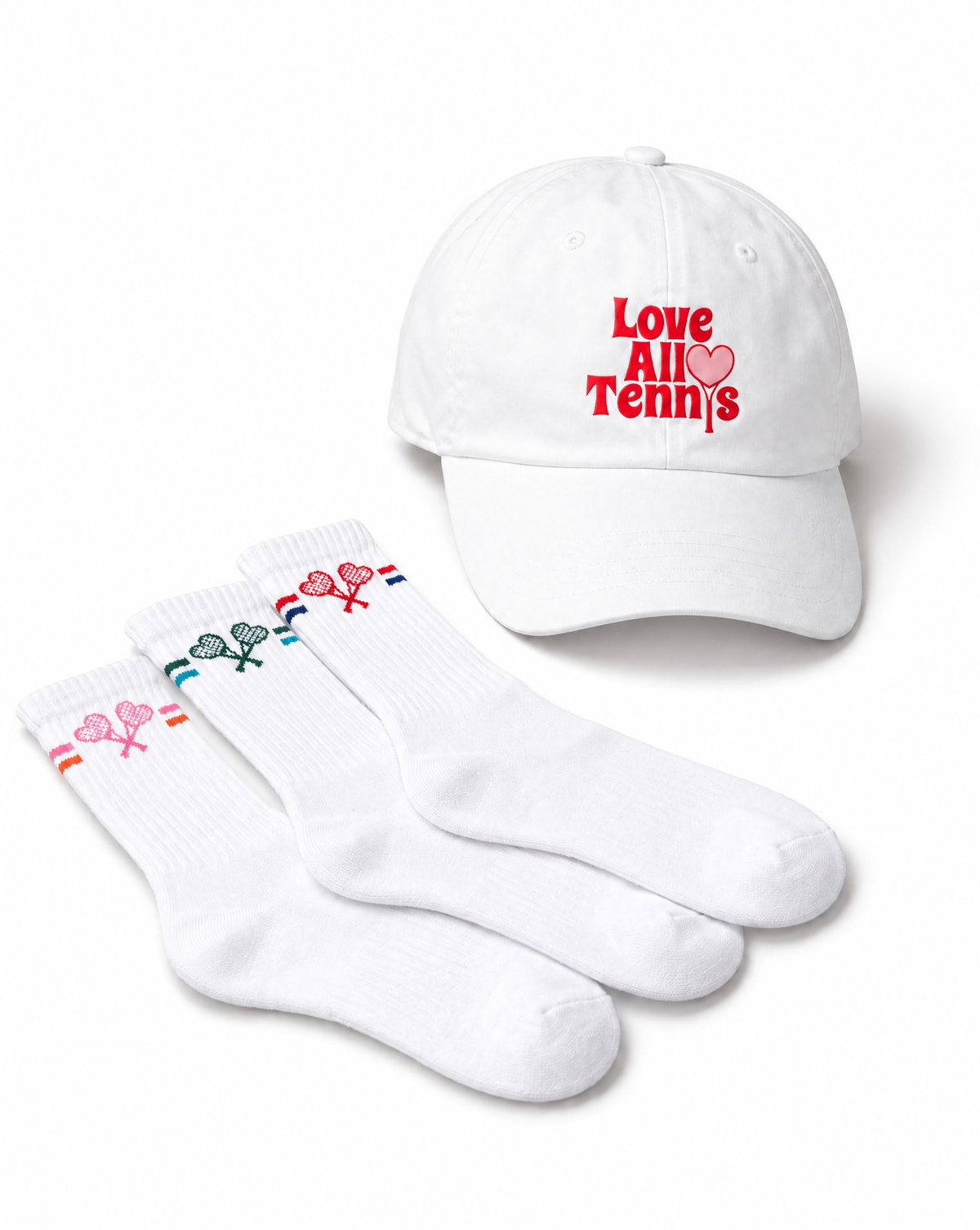 A white baseball cap with red embroidered text reading 'Love All Tennis' and three white ankle socks with small tennis racket and heart graphics in different colors, arranged on a white background.