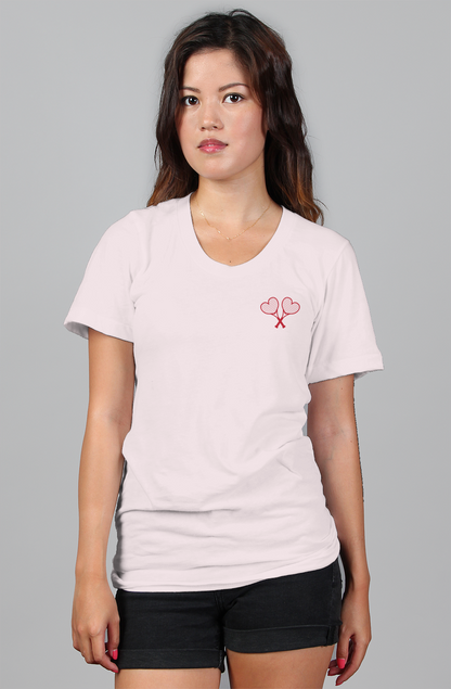 Woman wearing a light pink t-shirt and black shorts on a gray background