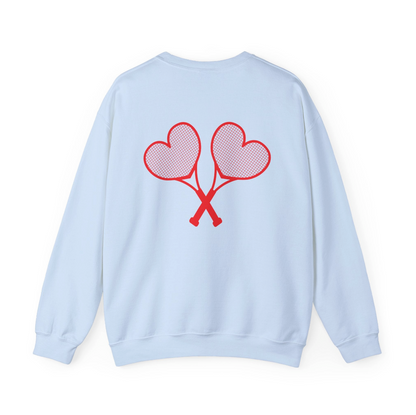 Light blue sweatshirt with red heart tennis rackets crossed on the back set against a white background