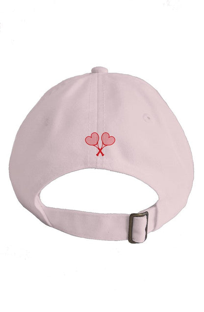 Pink cap with red heart and tennis racket design on a white background