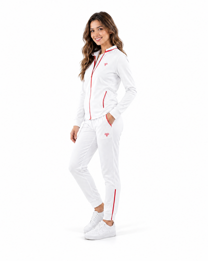 A woman modeling a white tracksuit with red trim, featuring a zip-up jacket and matching pants, against a solid white background.