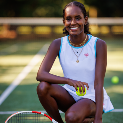 Woman on a tennis court holding a tennis racket and ball