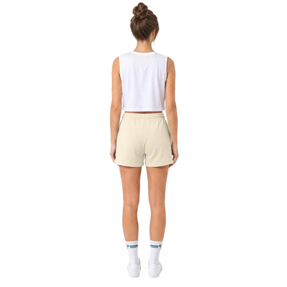 A model shown from the back wearing a white sleeveless crop top, light beige shorts, white socks, and white sneakers against a solid white background.