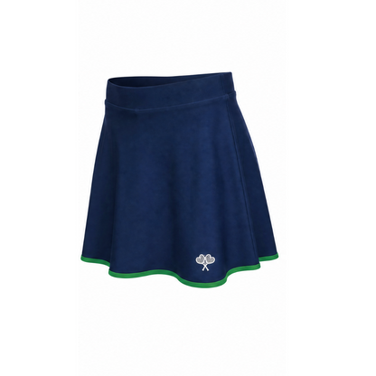 A navy blue flared skort with a thin green trim along the hem and a small white embroidered shamrock logo near the bottom right, shown against a plain white background.