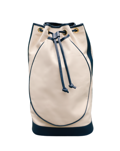 A cream-colored leather bucket bag with dark navy blue trim, drawstring, and base, accented with gold-tone grommets, shown against a plain white background.