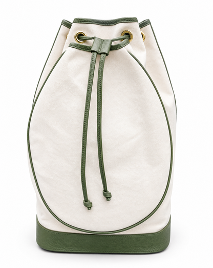 An off-white canvas bucket bag with olive green leather trim, drawstring, and base, featuring gold-tone eyelets.
