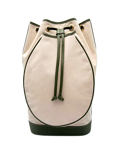 A canvas bucket bag in a light beige color with dark green trim, drawstring, and base, featuring gold-tone grommets on a white background.